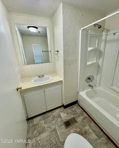 a bathroom with a sink mirror and a bathtub