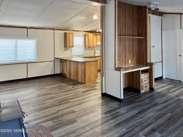 a kitchen with stainless steel appliances wooden floor and more cabinets