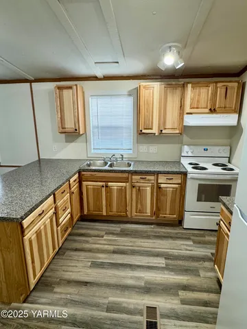 a kitchen with stainless steel appliances granite countertop a stove a sink and a microwave