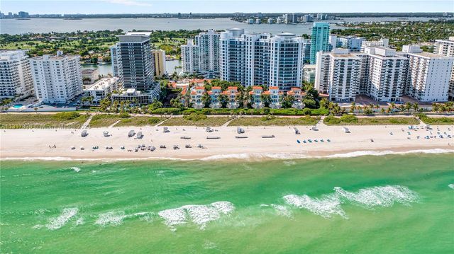 a view of a swimming pool with lawn chairs and plants