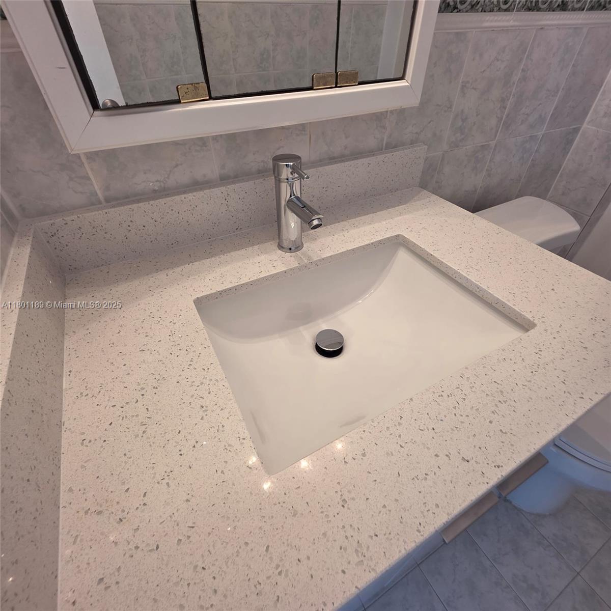 2350 Northeast 135th Street, Unit 1010 North Miami, FL 33181 - Photo 12 of 23 a bathroom with a granite countertop sink
