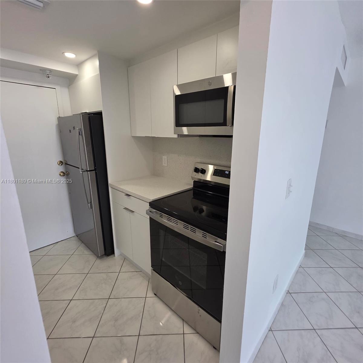 2350 Northeast 135th Street, Unit 1010 North Miami, FL 33181 - Photo 7 of 23 a kitchen with a refrigerator and a sink
