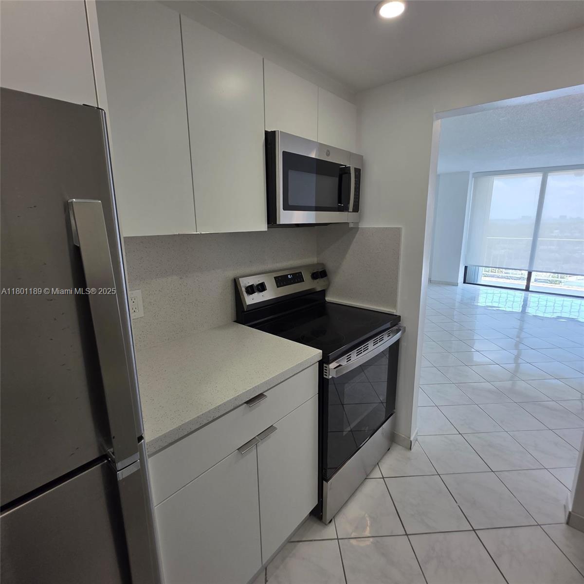 2350 Northeast 135th Street, Unit 1010 North Miami, FL 33181 - Photo 8 of 23 a kitchen with a sink and a refrigerator