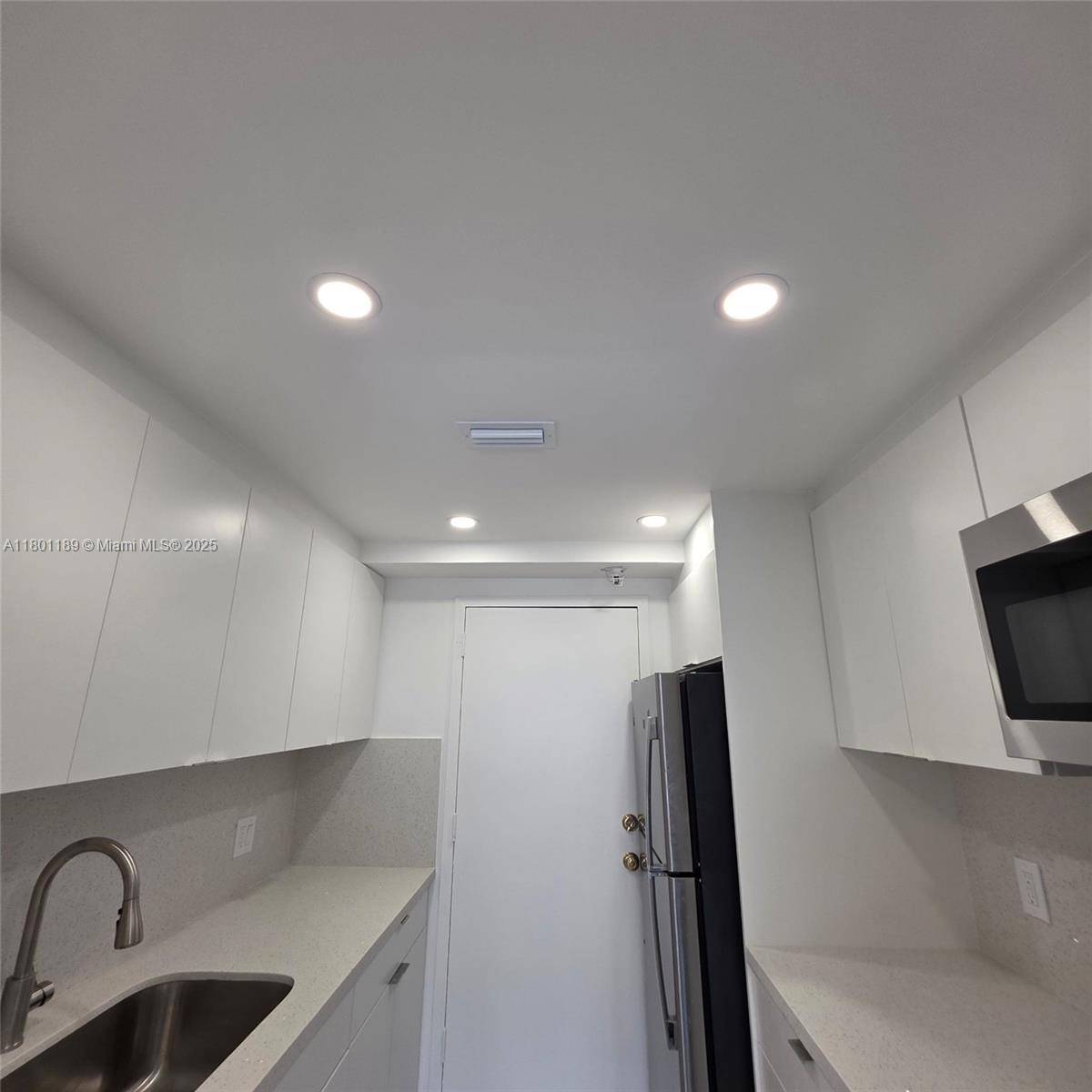 2350 Northeast 135th Street, Unit 1010 North Miami, FL 33181 - Photo 9 of 23 a view of a sink refrigerator and window