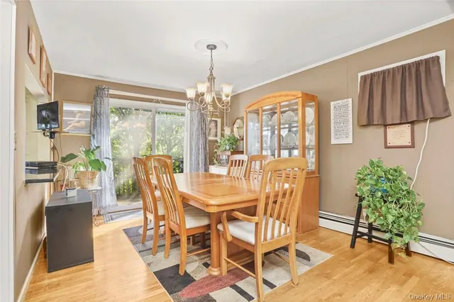 a dining room with furniture a chandelier and wooden floor