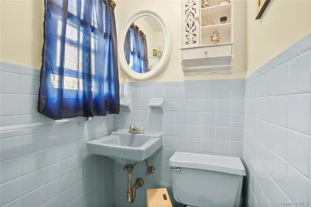 a bathroom with a toilet a sink and a mirror