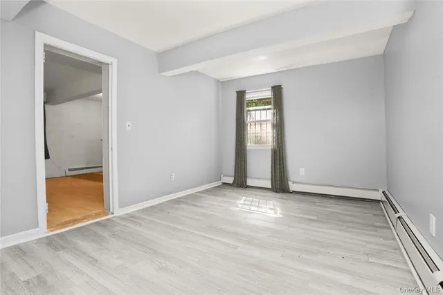 an empty room with wooden floor and a window