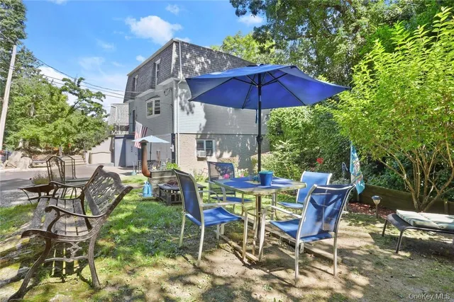 a view of patio with chairs and table under an umbrella
