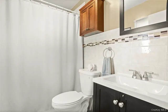 a bathroom with a granite countertop sink a toilet and a mirror