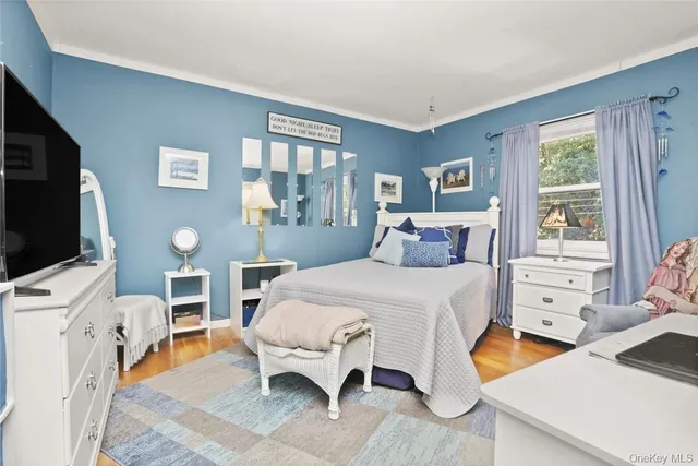 a bedroom with a bed and a flat tv screen on the dresser