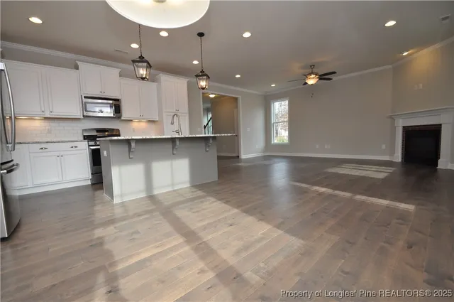 an open kitchen with kitchen island a sink stainless steel appliances and cabinets