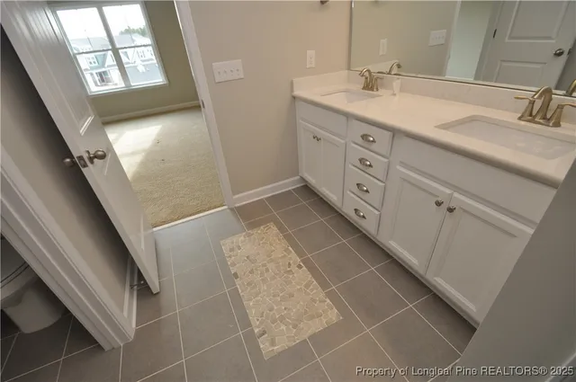 a spacious bathroom with a granite countertop sink a toilet mirror and a bathtub