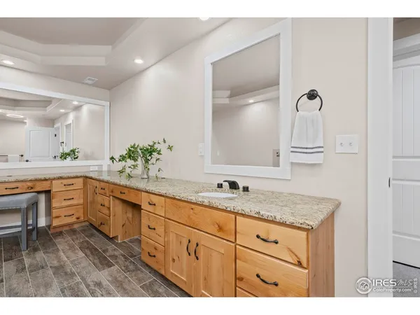 a spacious bathroom with a granite countertop sink mirror and bathtub