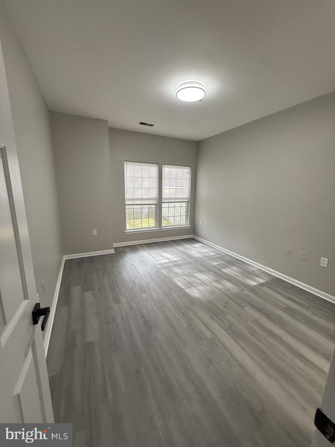 4400 Silverbrook Lane, Unit F003 Owings Mills, MD 21117 - Photo 11 of 17 wooden floor in an empty room with a window