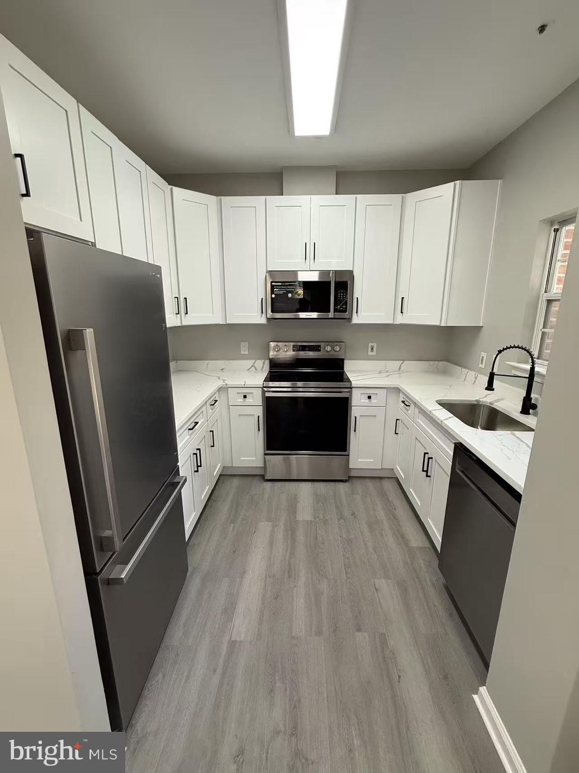 4400 Silverbrook Lane, Unit F003 Owings Mills, MD 21117 - Photo 3 of 17 a kitchen with stainless steel appliances a refrigerator sink and microwave
