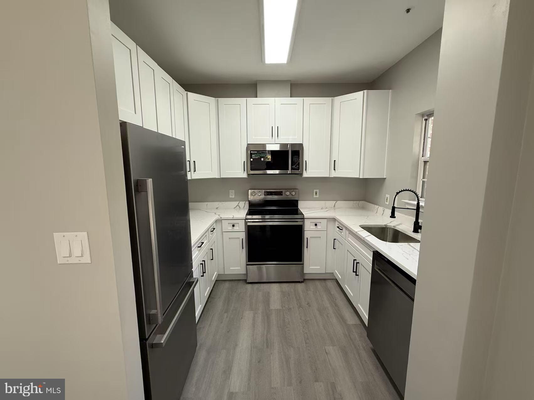4400 Silverbrook Lane, Unit F003 Owings Mills, MD 21117 - Photo 4 of 17 a kitchen with a sink a stove a refrigerator and cabinets
