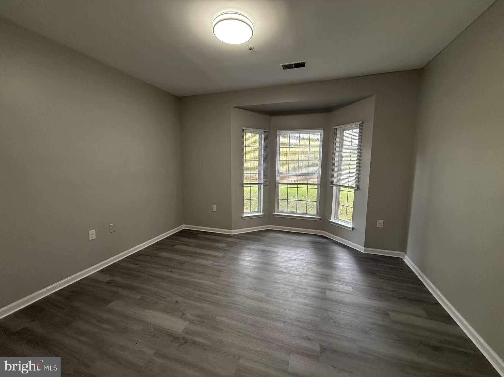 4400 Silverbrook Lane, Unit F003 Owings Mills, MD 21117 - Photo 6 of 17 an empty room with wooden floor and windows