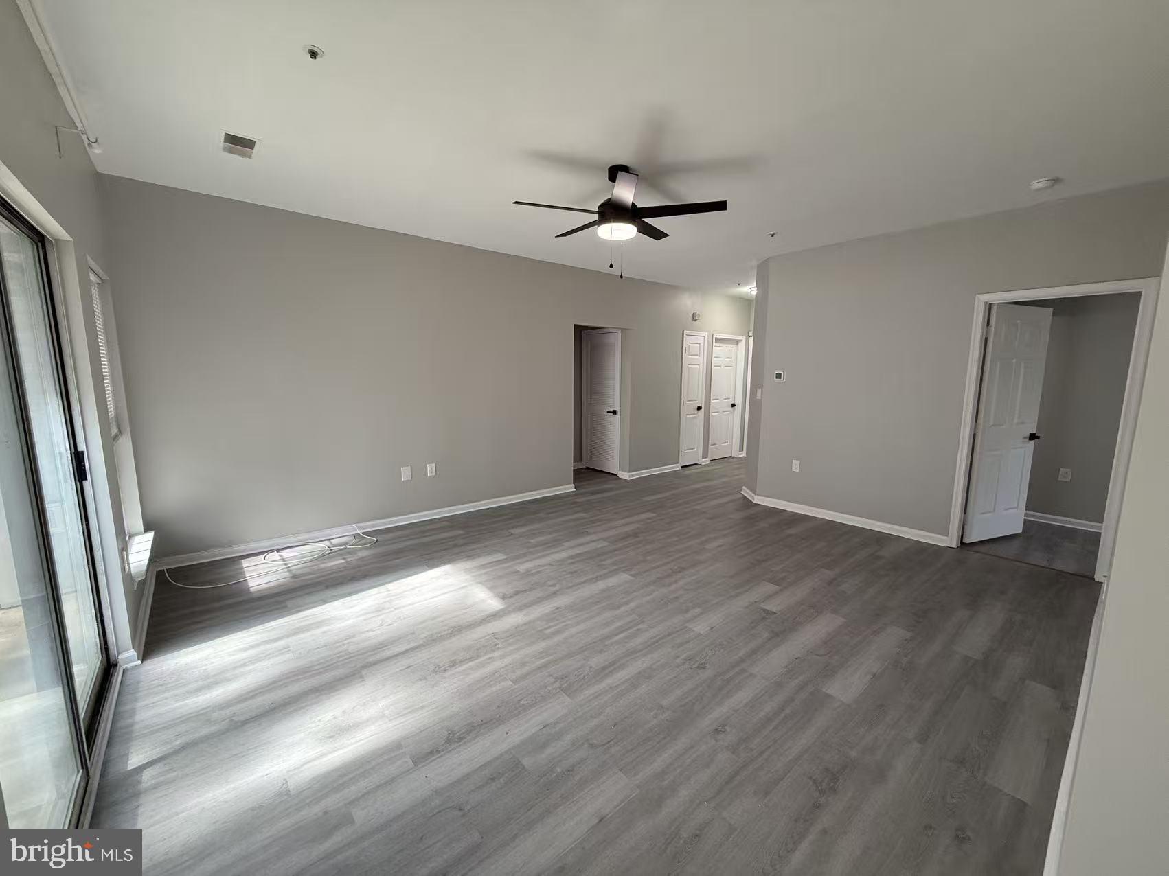 4400 Silverbrook Lane, Unit F003 Owings Mills, MD 21117 - Photo 7 of 17 a view of empty room with wooden floor and fan