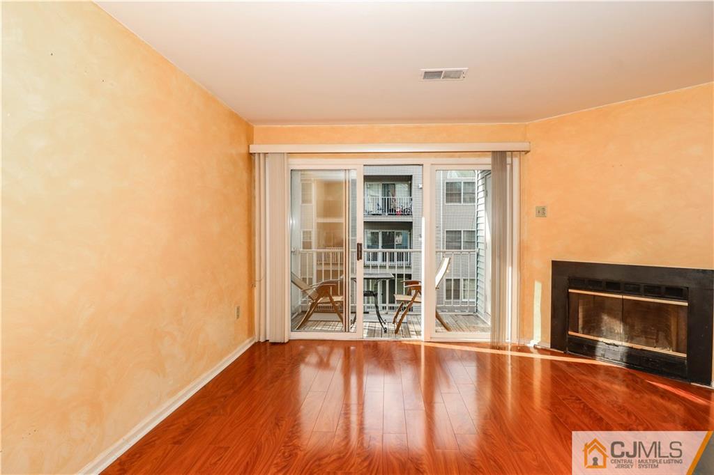 825 Edpas Road, Unit 825 New Brunswick, NJ 08901 - Photo 10 of 25 an empty room with wooden floor and fireplace