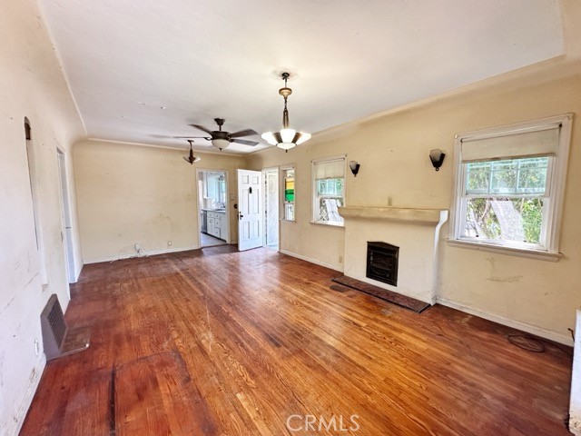 9700 Mayne Street Bellflower, CA 90706 - Photo 2 of 8 a view of a livingroom with wooden floor a fireplace and windows