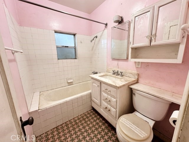 9700 Mayne Street Bellflower, CA 90706 - Photo 4 of 8 a bathroom with a granite countertop toilet sink and a bathtub