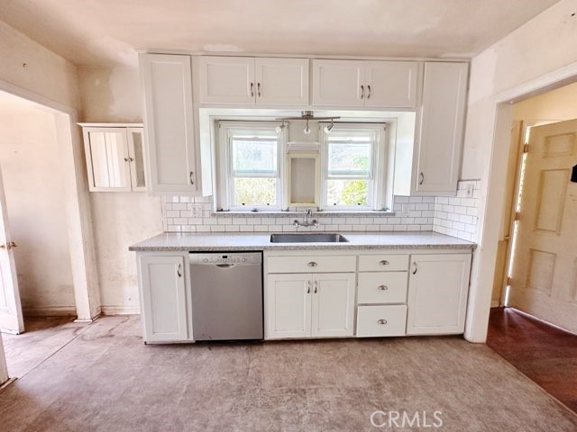 9700 Mayne Street Bellflower, CA 90706 - Photo 7 of 8 a kitchen with granite countertop white cabinets white appliances a sink and a window