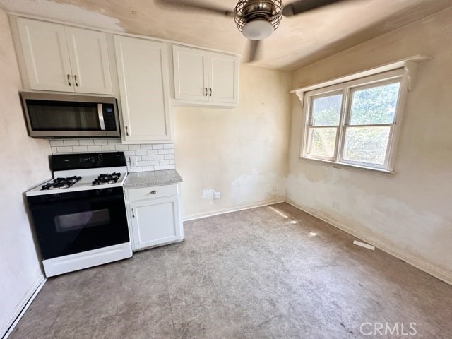 9700 Mayne Street Bellflower, CA 90706 - Photo 8 of 8 a kitchen with stainless steel appliances white cabinets and a stove top oven