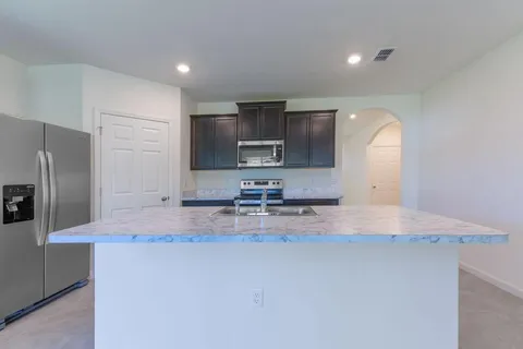 a kitchen with stainless steel appliances granite countertop a sink refrigerator and microwave
