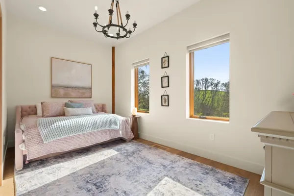 a spacious bedroom with a bed and a flat screen tv