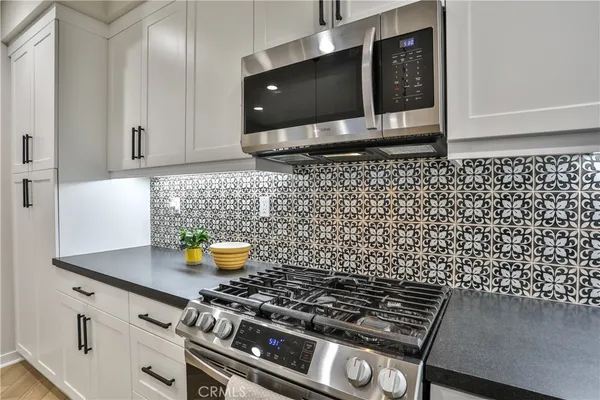 a kitchen with a sink a counter space appliances and cabinets