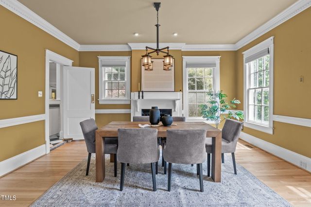 a kitchen with stainless steel appliances granite countertop a refrigerator a stove a sink and white cabinets with wooden floor