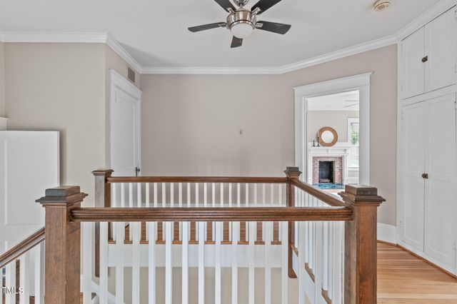 a view of an empty room and wooden floor and a ceiling fan