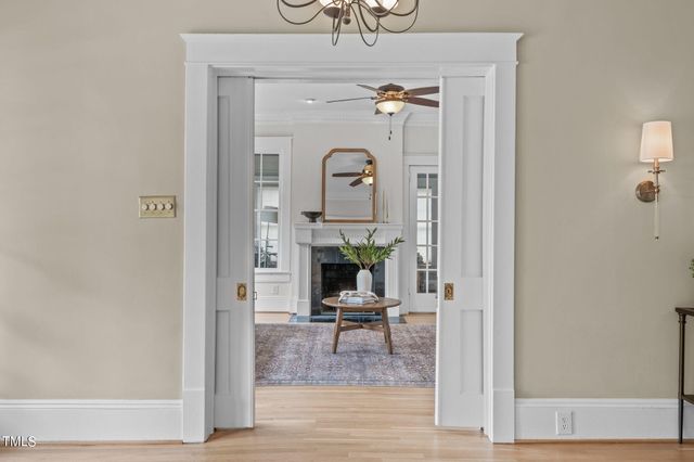 a living room with furniture a fireplace and a chandelier