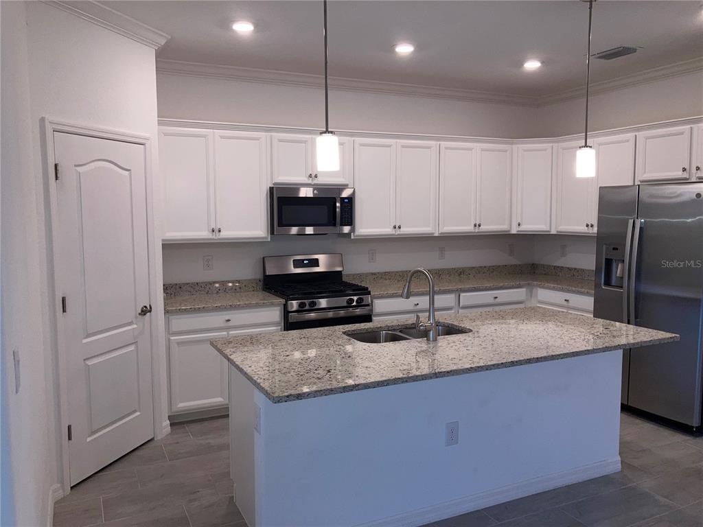 6511 Clairborne Lane Bradenton, FL 34211 - Photo 3 of 12 a kitchen with stainless steel appliances granite countertop a sink a stove and a refrigerator
