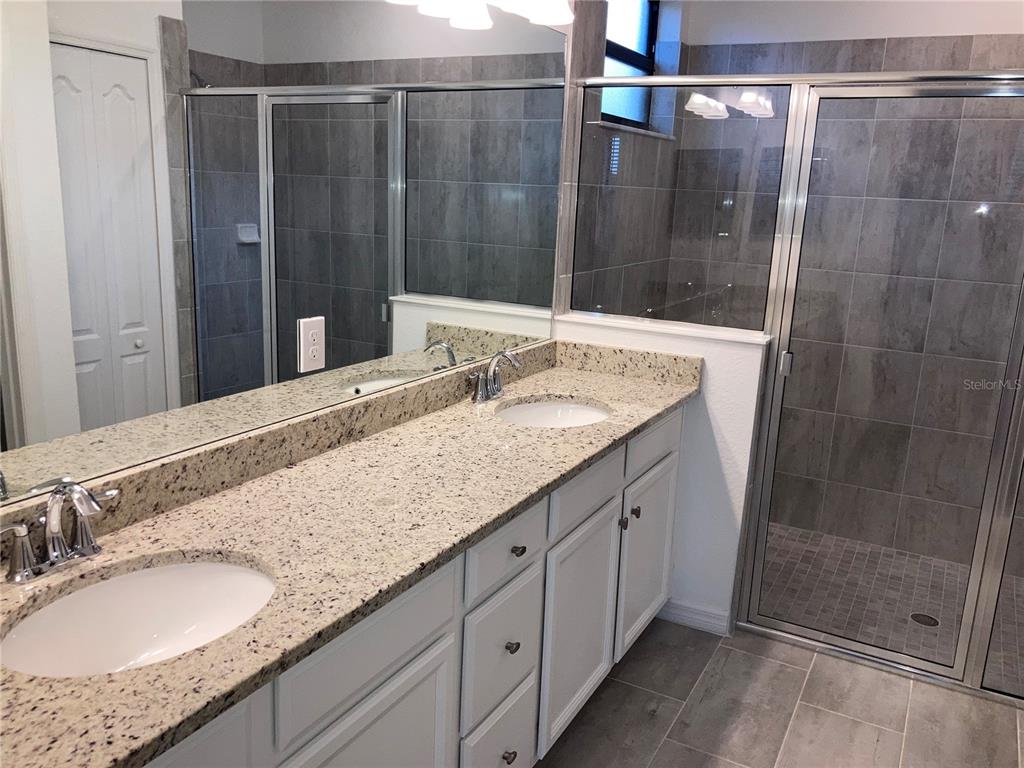 6511 Clairborne Lane Bradenton, FL 34211 - Photo 6 of 12 a bathroom with a granite countertop sink a mirror and shower
