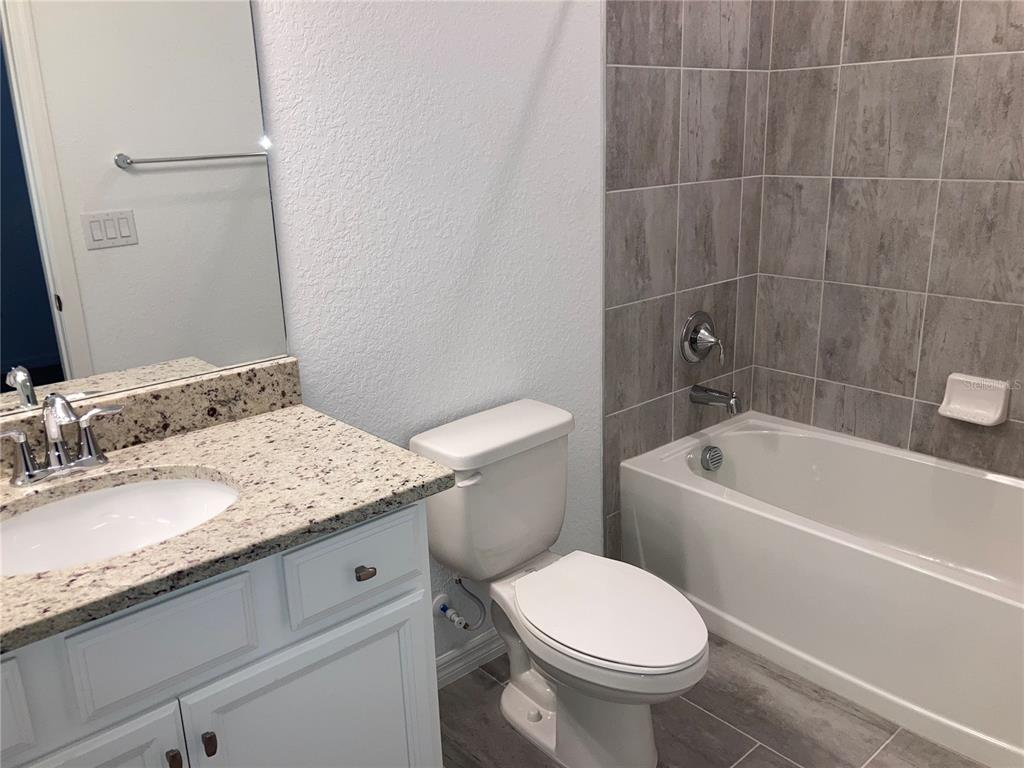 6511 Clairborne Lane Bradenton, FL 34211 - Photo 7 of 12 a bathroom with a granite countertop toilet a sink and bathtub