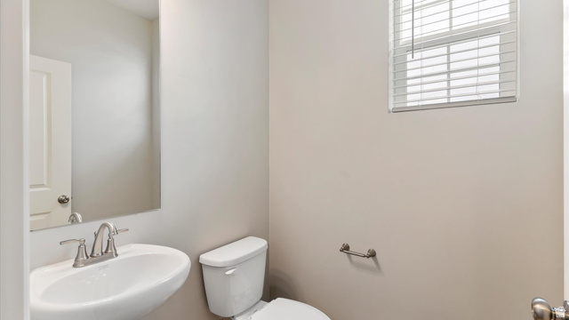 82 Provo River Road, Unit 251 Saratoga Springs, UT 84045 - Photo 28 of 32 Compact bathroom featuring a white wall-mounted sink with a brushed nickel faucet, a white toilet, and a rectangular mirror