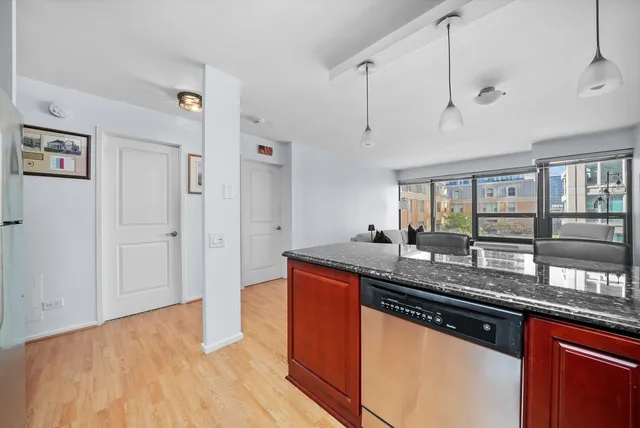 a kitchen with stainless steel appliances granite countertop a sink and wooden floor
