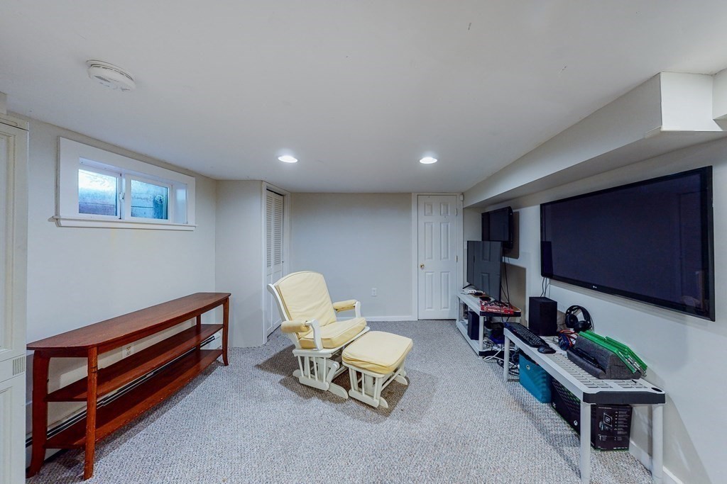 14 Gordon Road Milton, MA 02186 - Photo 27 of 38 a living room with furniture a desk and a flat screen tv