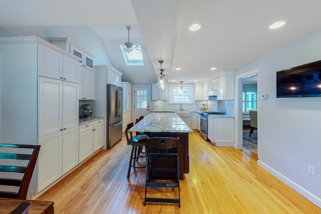 14 Gordon Road Milton, MA 02186 - Photo 8 of 38 a kitchen with a table chairs refrigerator and microwave