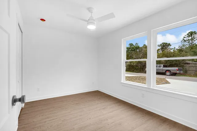 a view of an empty room with wooden floor
