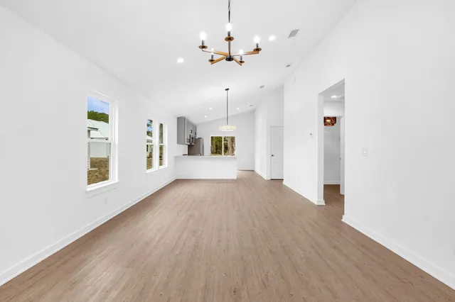 a view of a livingroom with wooden floor and a ceiling fan