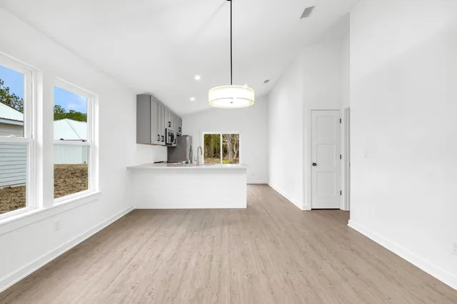 a view of a room with wooden floor and windows