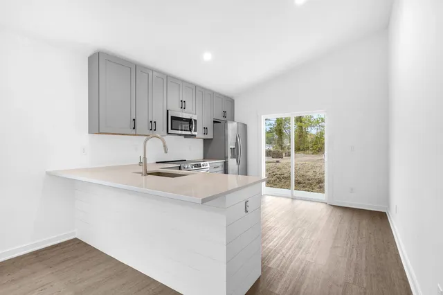 a kitchen with a sink a stove and cabinets