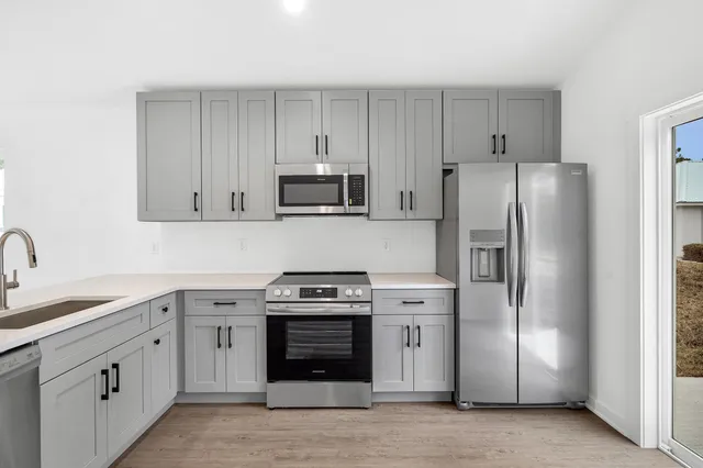 a kitchen with stainless steel appliances granite countertop a refrigerator stove and sink