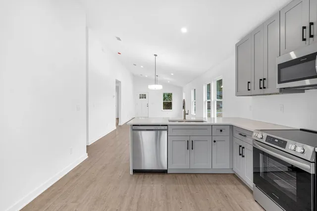 a kitchen with stainless steel appliances granite countertop a stove a sink and a refrigerator