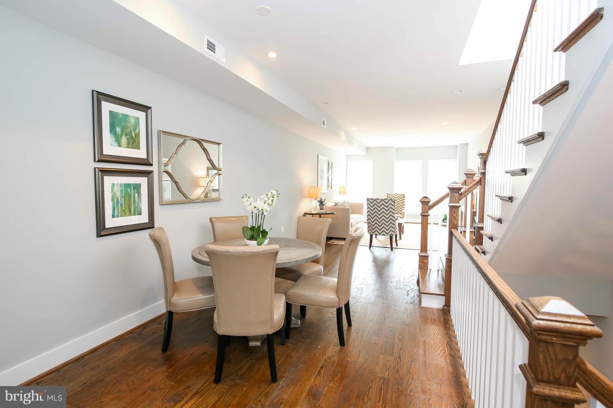 423 7th Street Southeast Washington, DC 20003 - Photo 17 of 29 a dining room with wooden floor a glass table and chairs