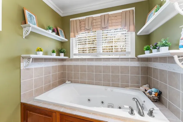 a bathroom with a bathtub a window and a shower