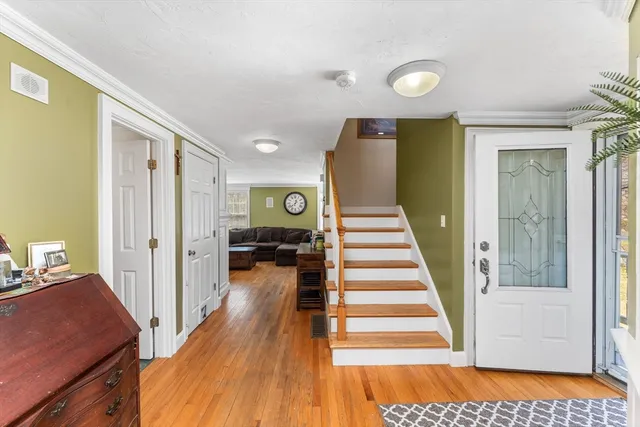 a view of a hallway with wooden floor and staircase