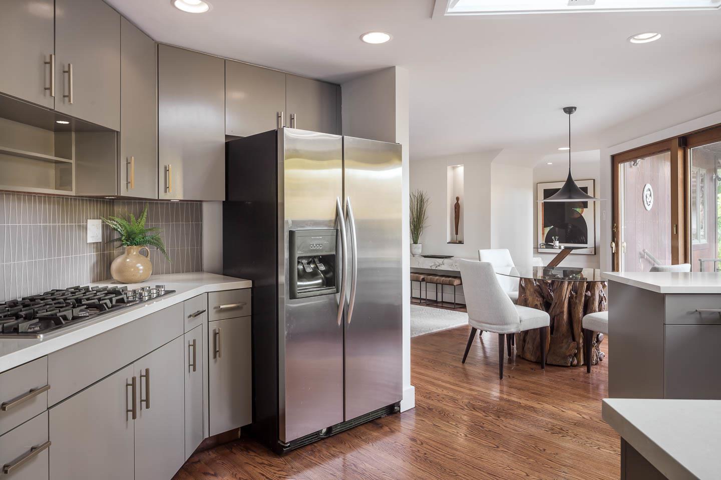 70 De Sabla Road San Mateo, CA 94402 - Photo 10 of 17 a kitchen with stainless steel appliances granite countertop a refrigerator a stove a sink and a dining table with wooden floor
